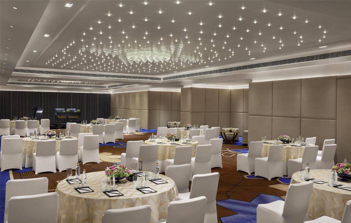 a banquet hall with white tables and white chairs at Hyatt Centric Sector17 Chandigarh in Chandīgarh