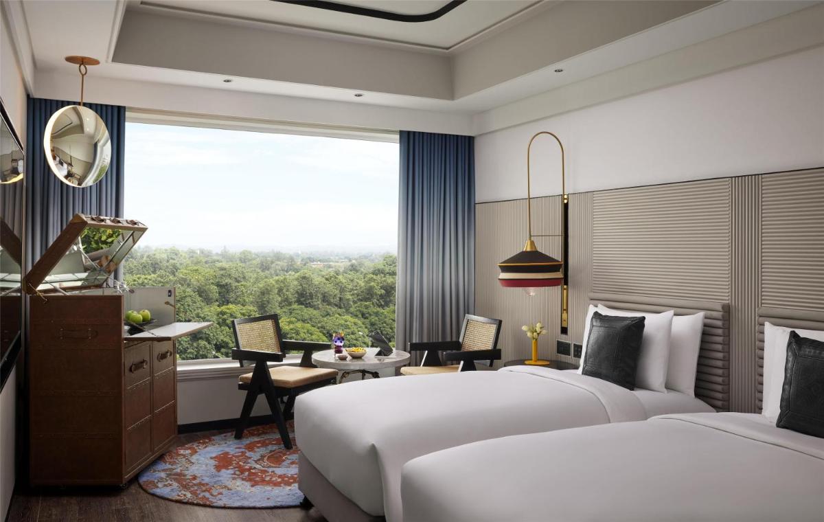 a hotel room with two beds and a desk and a window at Hyatt Centric Sector17 Chandigarh in Chandīgarh