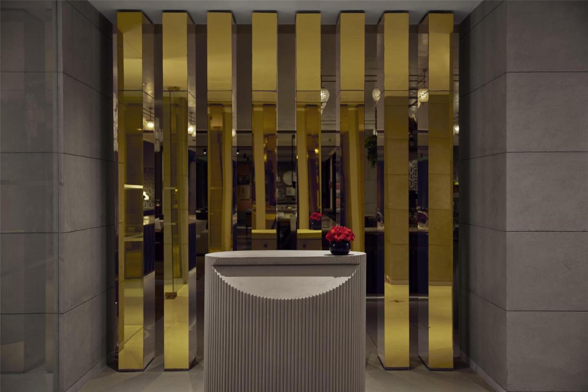 a lobby with yellow columns and a table with a flower at Hyatt Centric Sector17 Chandigarh in Chandīgarh
