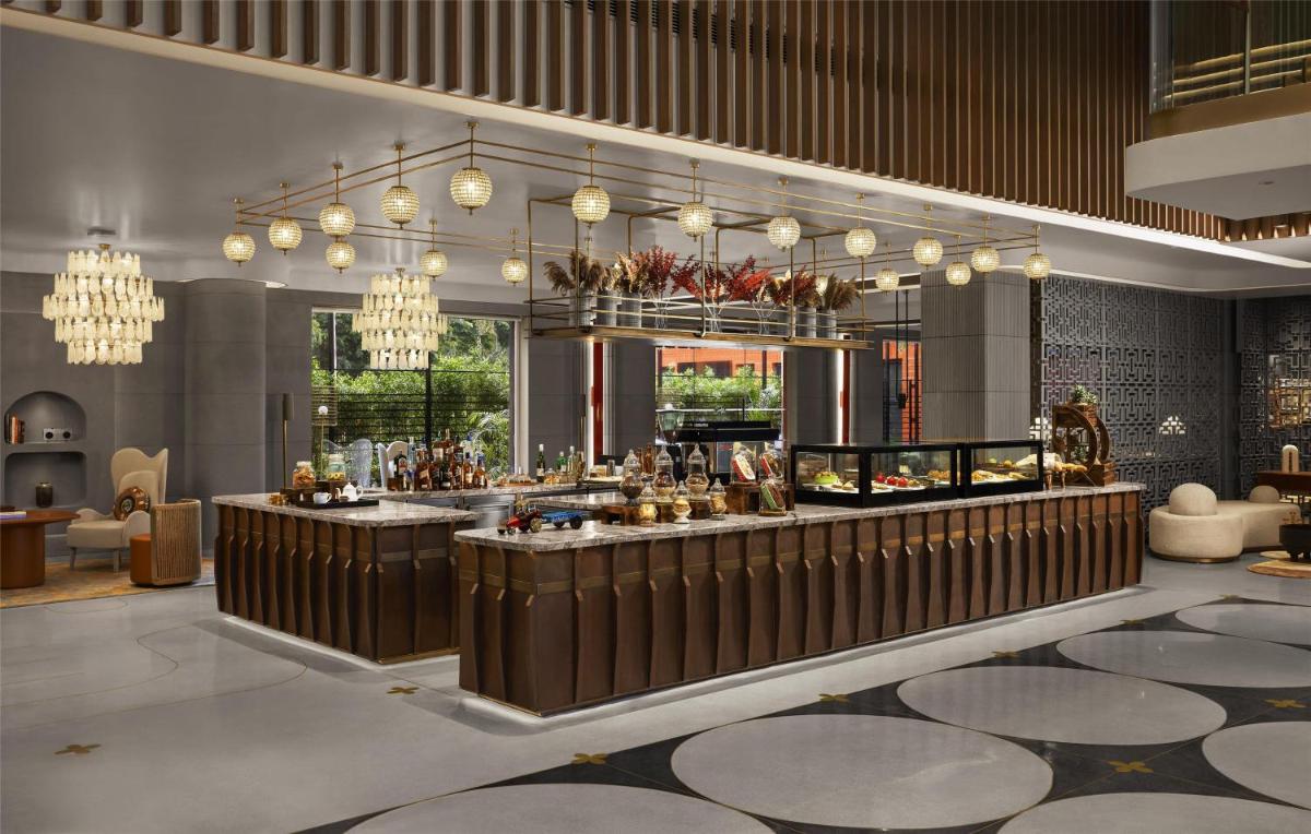a lobby with a bar and chandeliers at Hyatt Centric Sector17 Chandigarh in Chandīgarh