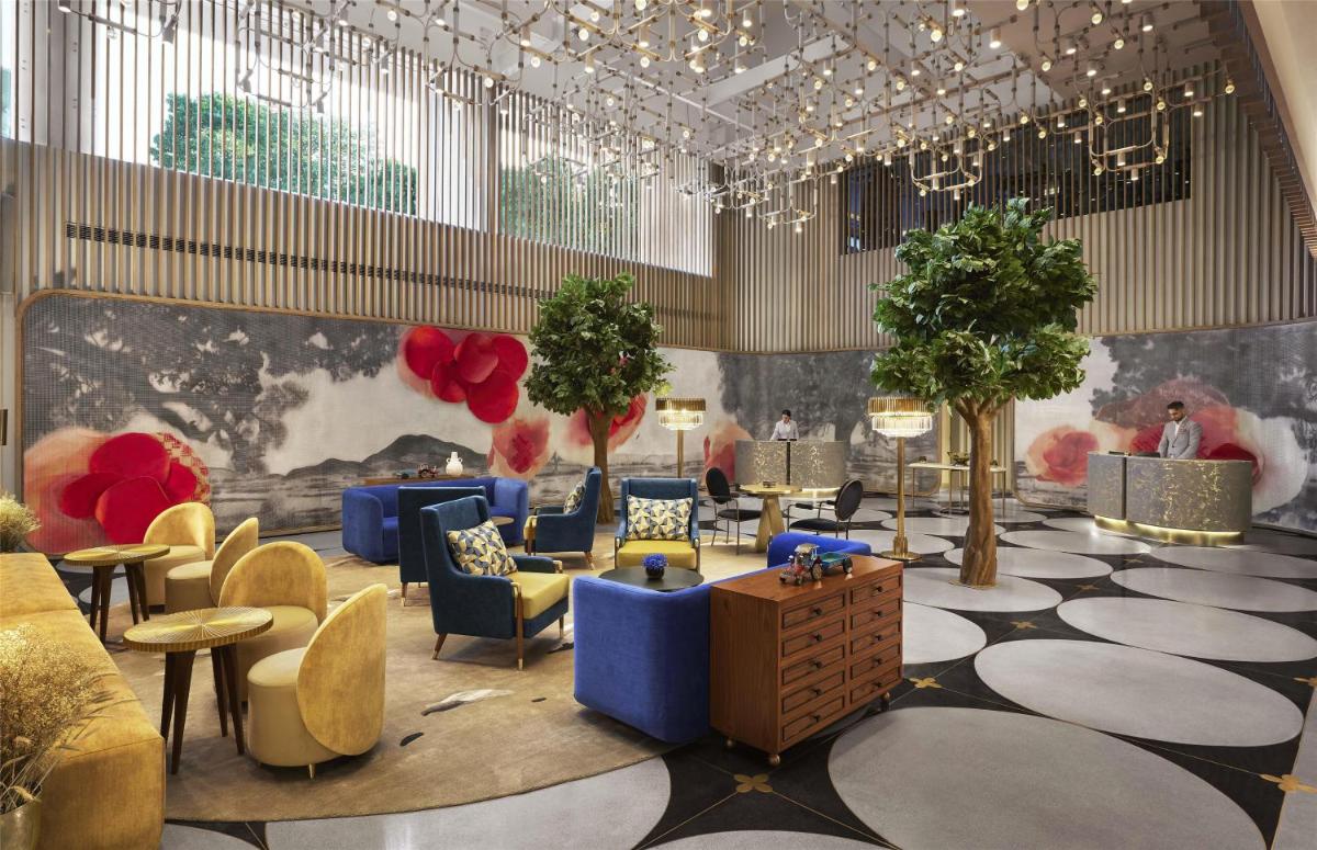 a lobby with blue chairs and tables and trees at Hyatt Centric Sector17 Chandigarh in Chandīgarh +111 photos