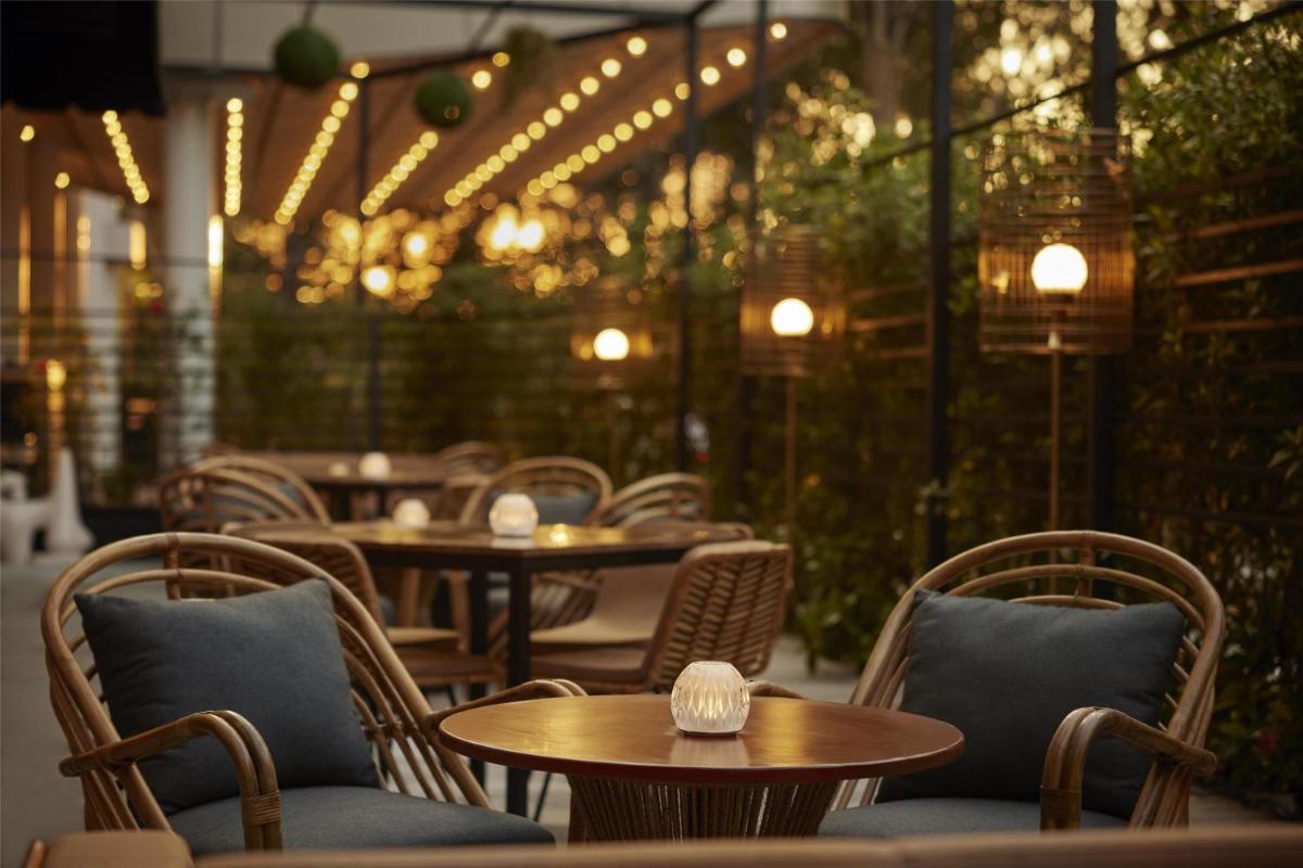 a restaurant with tables and chairs and lights at Hyatt Centric Sector17 Chandigarh in Chandīgarh