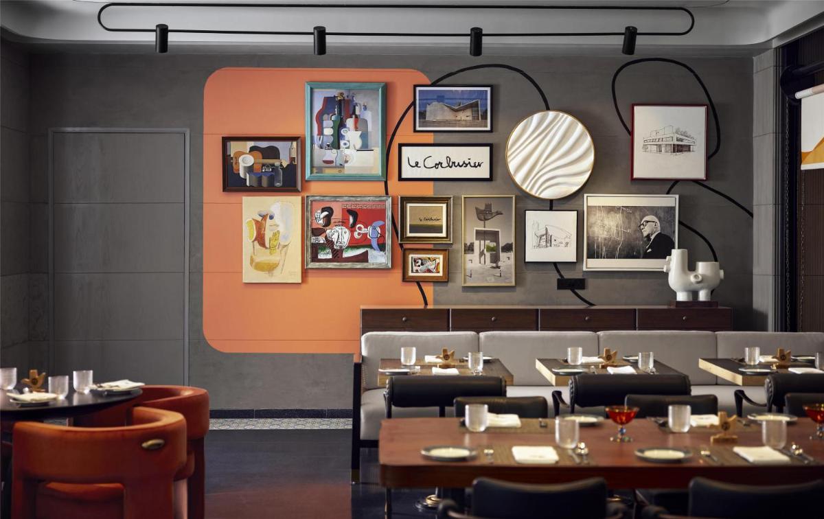 a dining room with tables and photos on the wall at Hyatt Centric Sector17 Chandigarh in Chandīgarh