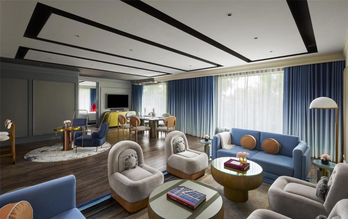 a living room with blue couches and chairs and a table at Hyatt Centric Sector17 Chandigarh in Chandīgarh