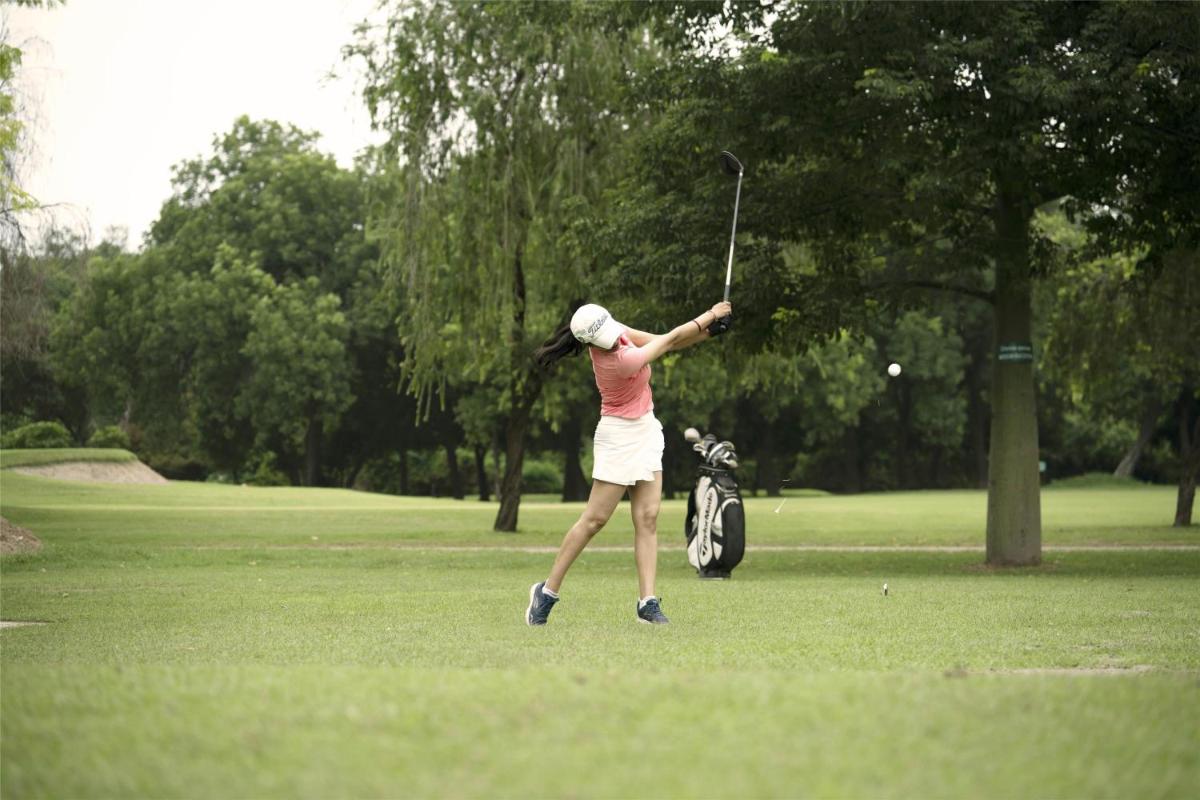 a woman hitting a golf ball with a club at Hyatt Centric Sector17 Chandigarh in Chandīgarh