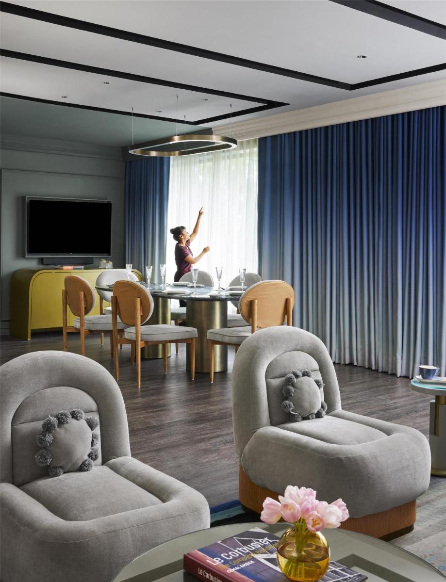 a woman in a room with chairs and a table at Hyatt Centric Sector17 Chandigarh in Chandīgarh