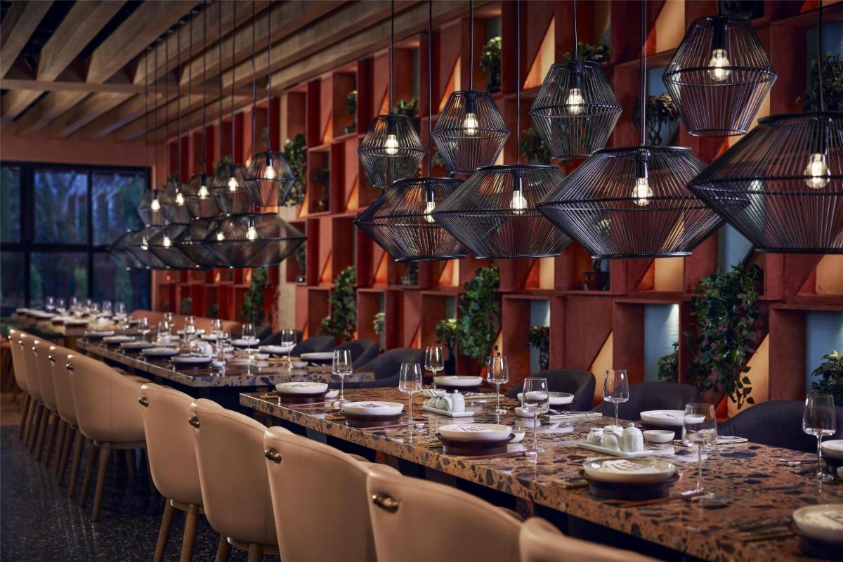 a long table in a room with chairs and lights at Hyatt Centric Sector17 Chandigarh in Chandīgarh