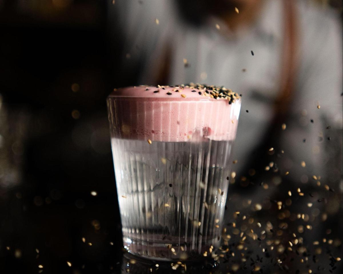 a glass filled with a pink drink with gold sprinkles at Hyatt Centric Sector17 Chandigarh in Chandīgarh