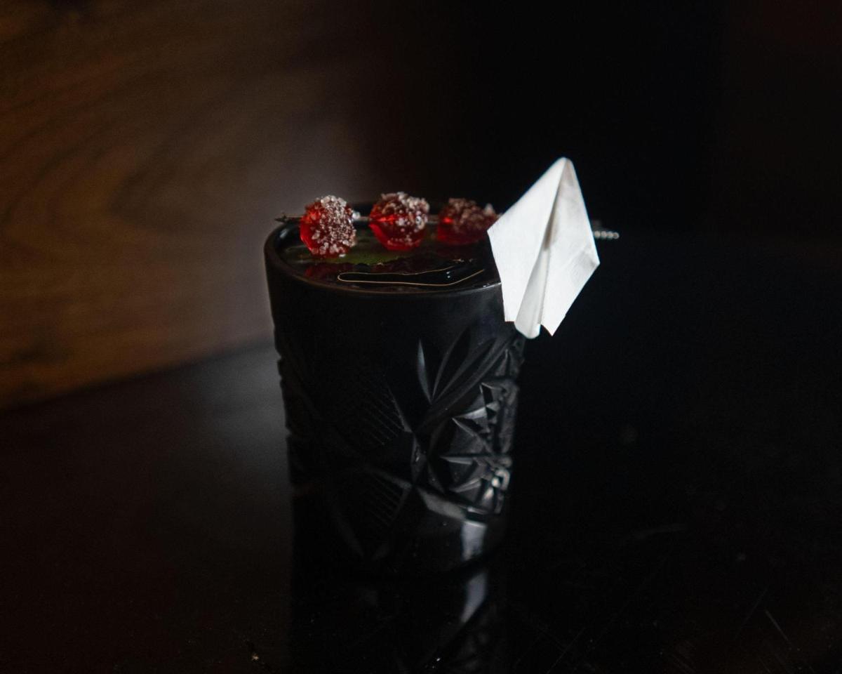 a black bottle with red berries on top of it at Hyatt Centric Sector17 Chandigarh in Chandīgarh