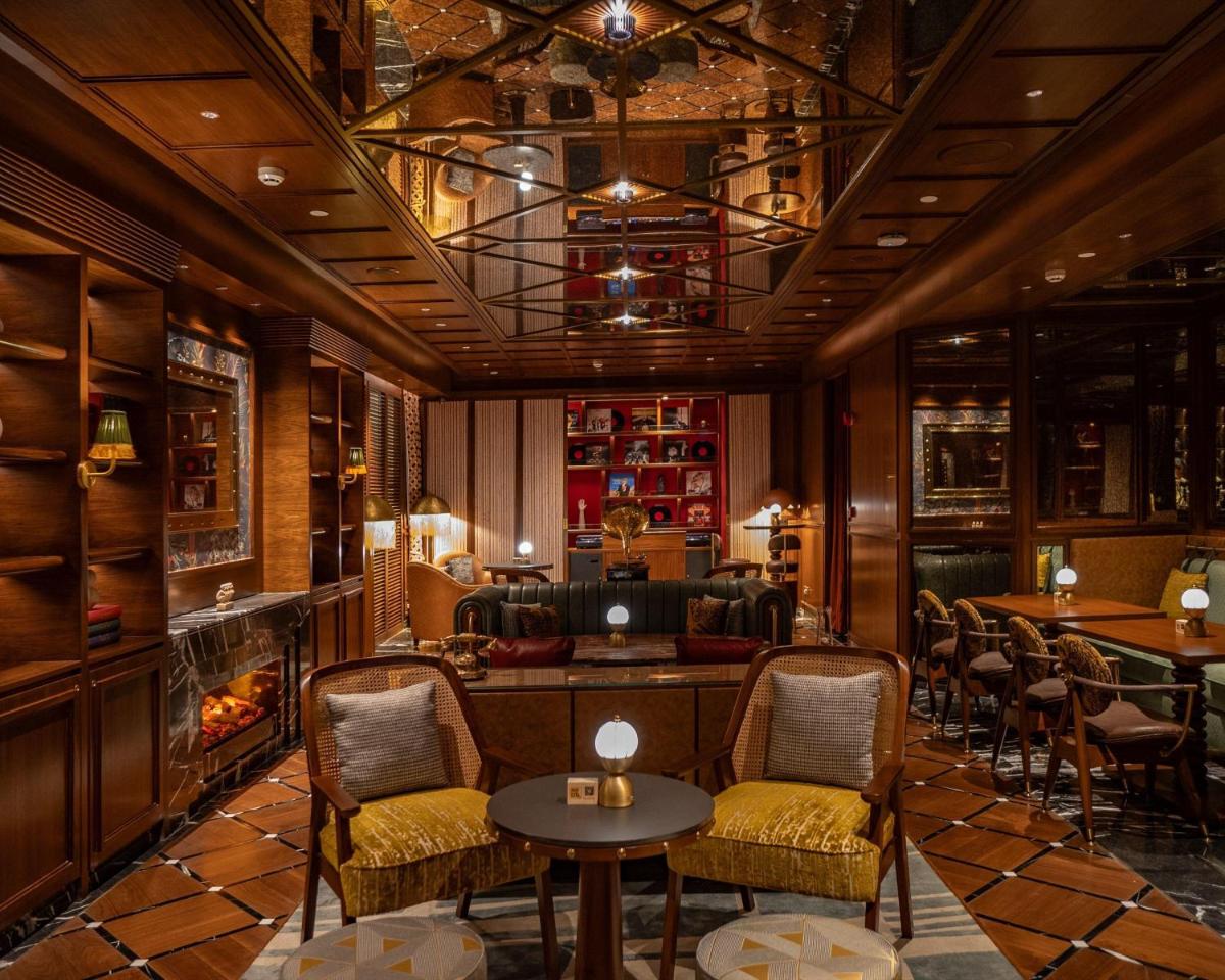 a bar with chairs and tables and a fireplace at Hyatt Centric Sector17 Chandigarh in Chandīgarh