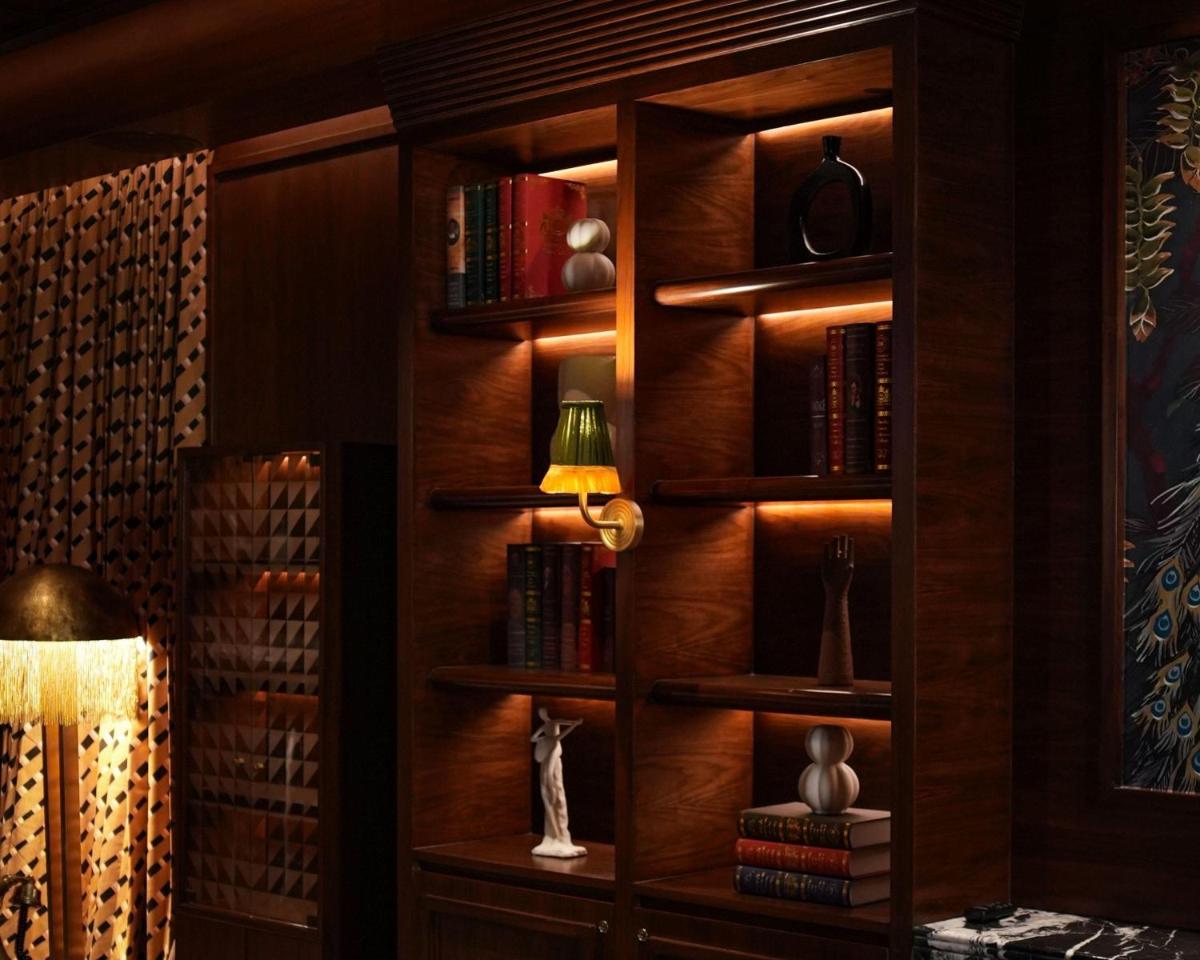 a library with wooden shelves with books and a lamp at Hyatt Centric Sector17 Chandigarh in Chandīgarh