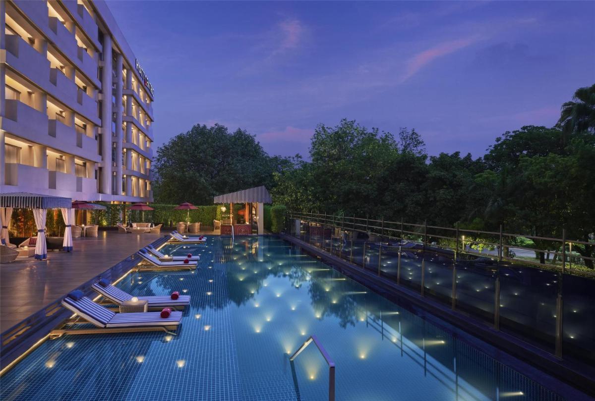 a hotel swimming pool with chairs and a building at Hyatt Centric Sector17 Chandigarh in Chandīgarh