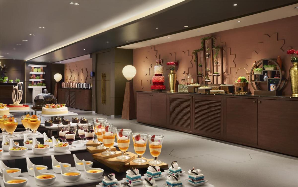 a buffet line with glasses of wine and desserts at Hyatt Centric Sector17 Chandigarh in Chandīgarh
