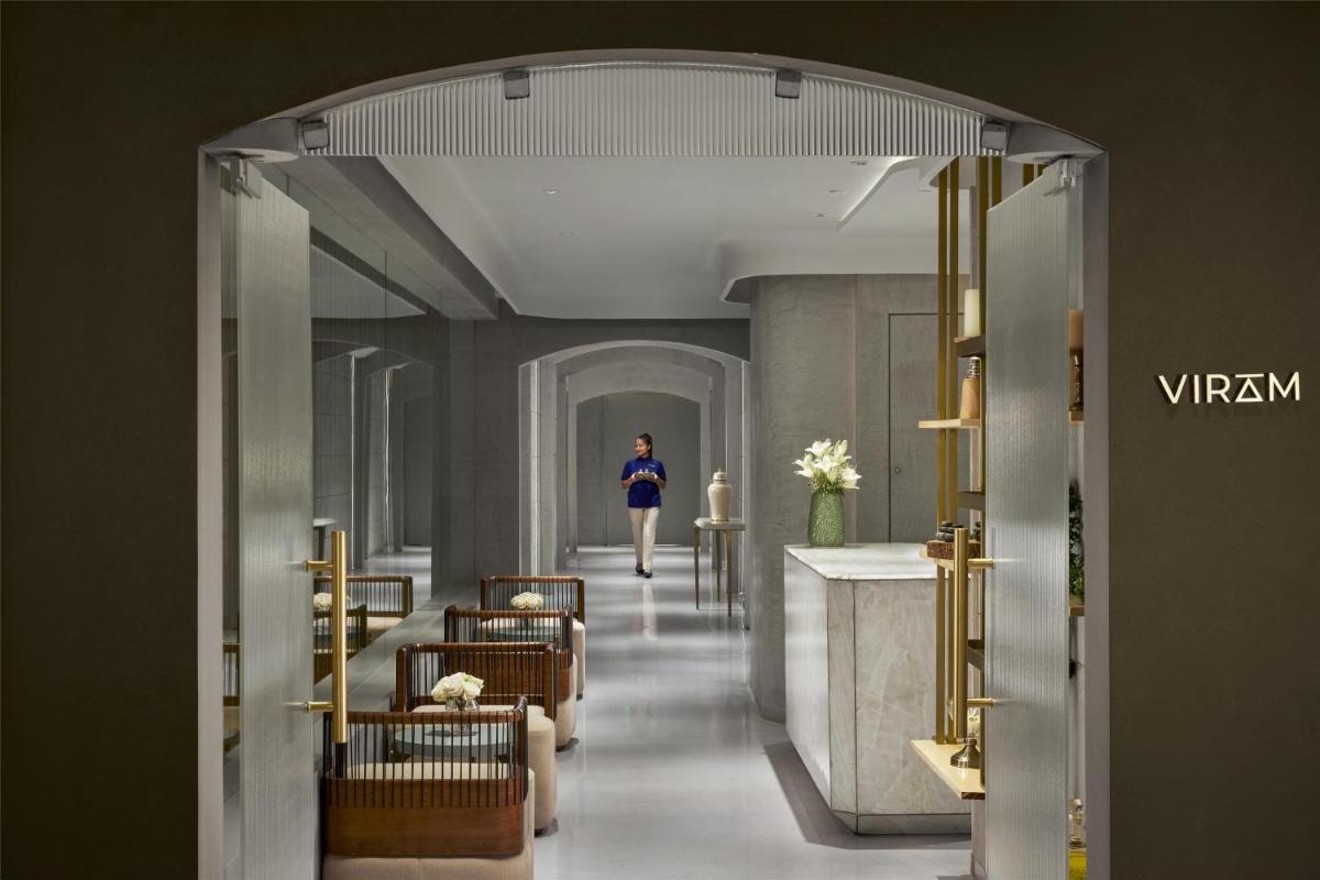 a woman walking down a hallway in a building at Hyatt Centric Sector17 Chandigarh in Chandīgarh