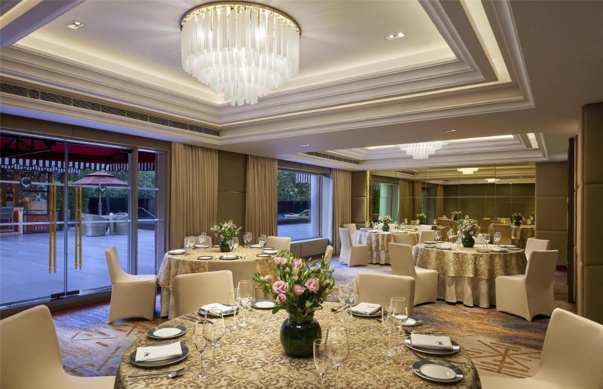 a banquet room with tables and chairs and a chandelier at Hyatt Centric Sector17 Chandigarh in Chandīgarh