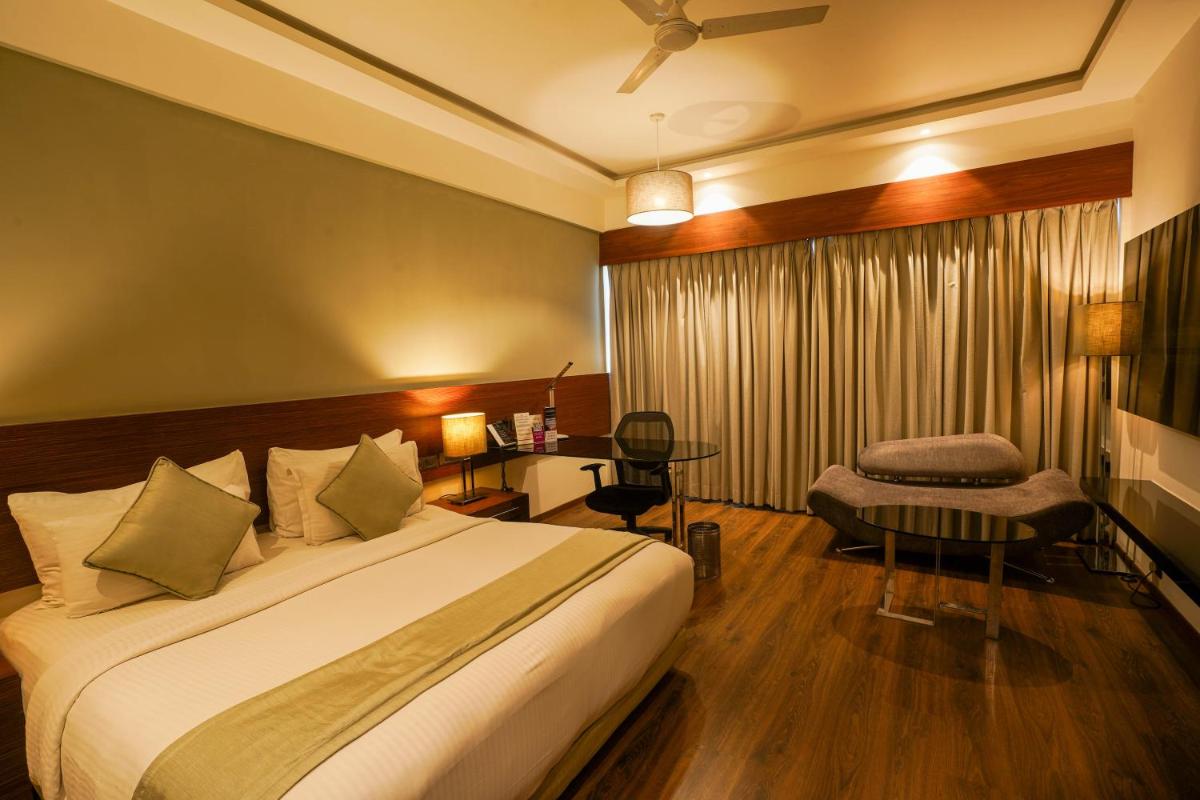 a hotel room with a bed and a desk at Southern Star,Mysore in Mysore