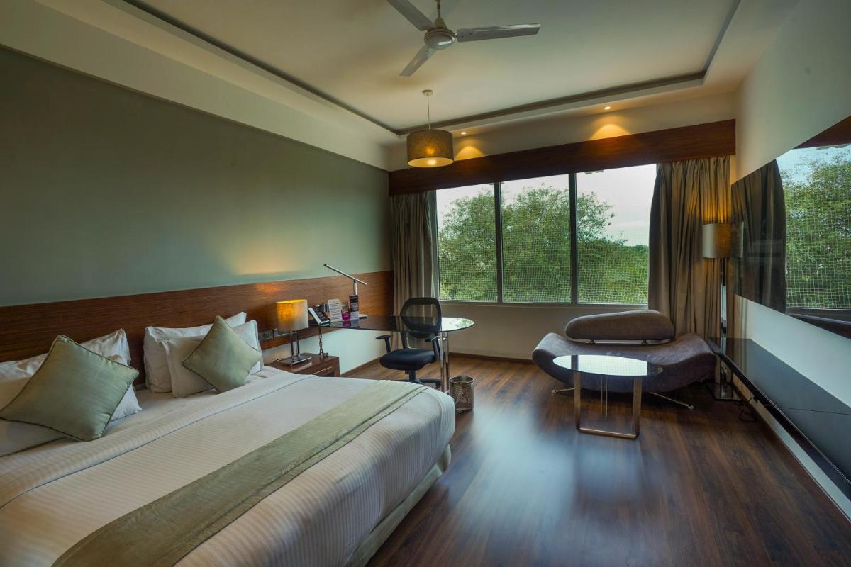 a hotel room with a large bed and a window at Southern Star,Mysore in Mysore
