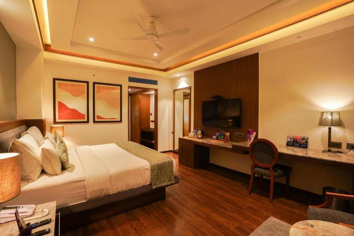 a hotel room with a bed and a desk at Southern Star,Mysore in Mysore