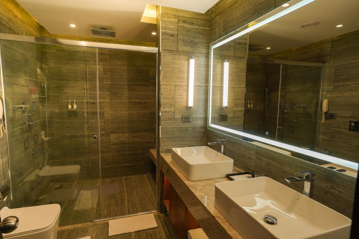 a bathroom with a sink and a shower and a mirror at Southern Star,Mysore in Mysore