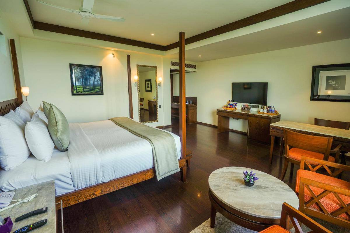 a hotel room with a bed and a dining room at Southern Star,Mysore in Mysore