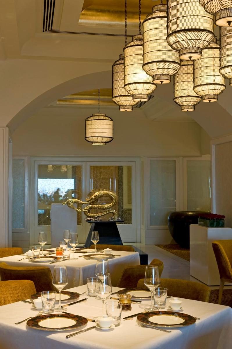 a dining room with white tables and chandeliers at The Taj Mahal Tower, Mumbai in Mumbai a dining room with white tables and chandeliers at The Taj Mahal Tower, Mumbai in Mumbai