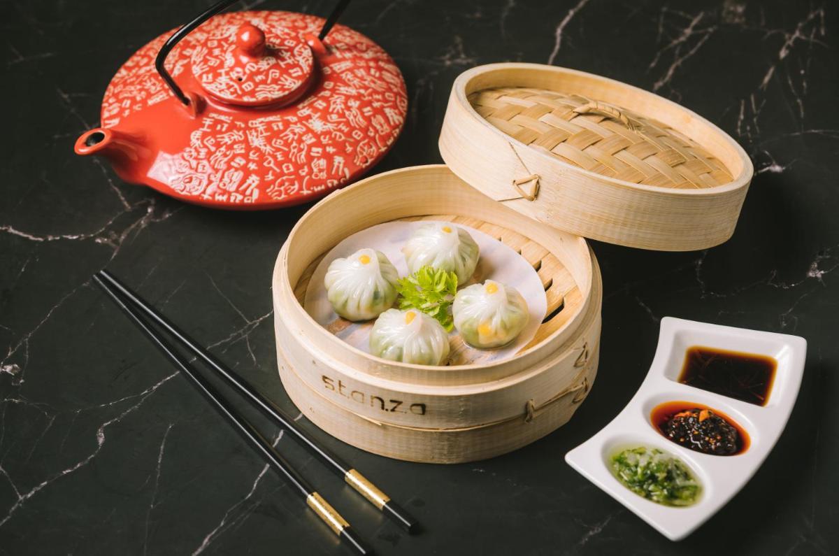 a wooden box filled with dumplings next to chopsticks at The Taj Mahal Tower, Mumbai in Mumbai a wooden box filled with dumplings next to chopsticks at The Taj Mahal Tower, Mumbai in Mumbai
