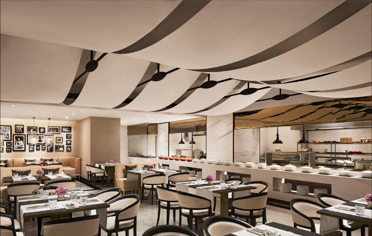 a dining room with tables and chairs and a restaurant at The Taj Mahal Tower, Mumbai in Mumbai a dining room with tables and chairs and a restaurant at The Taj Mahal Tower, Mumbai in Mumbai