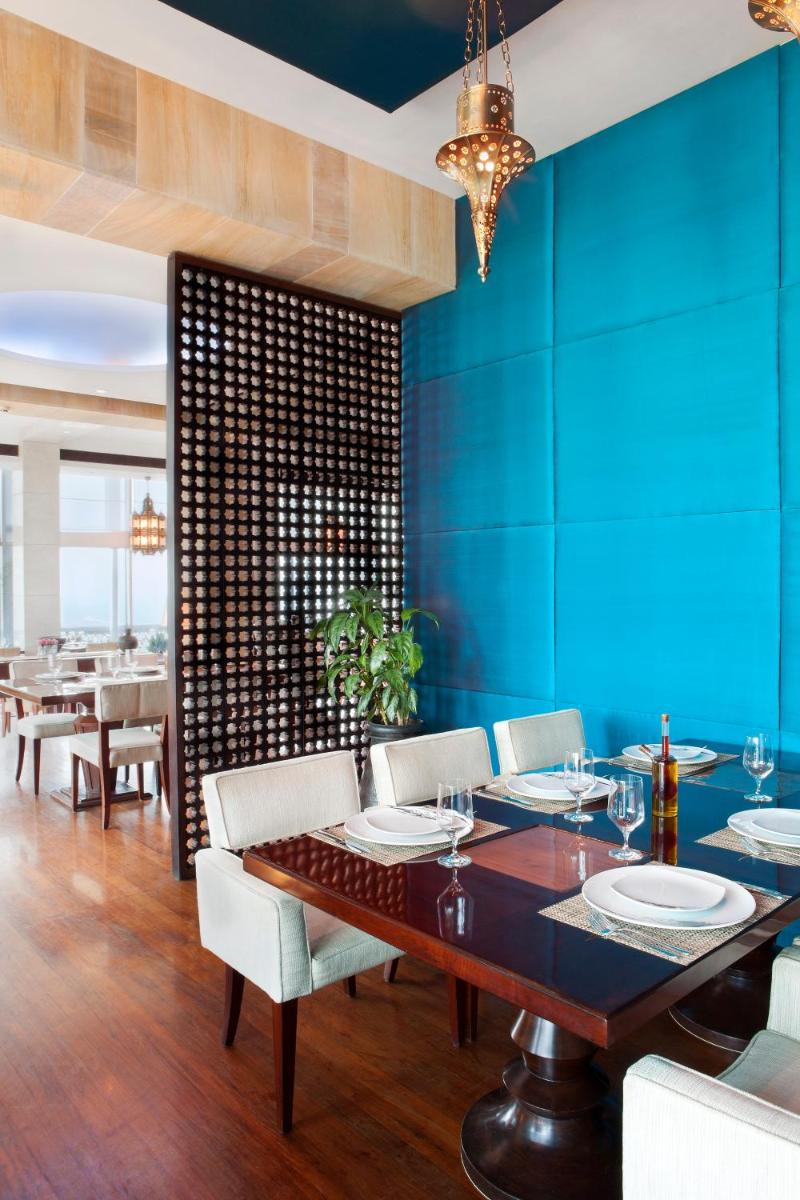 a dining room with a table and a blue wall at The Taj Mahal Tower, Mumbai in Mumbai a dining room with a table and a blue wall at The Taj Mahal Tower, Mumbai in Mumbai