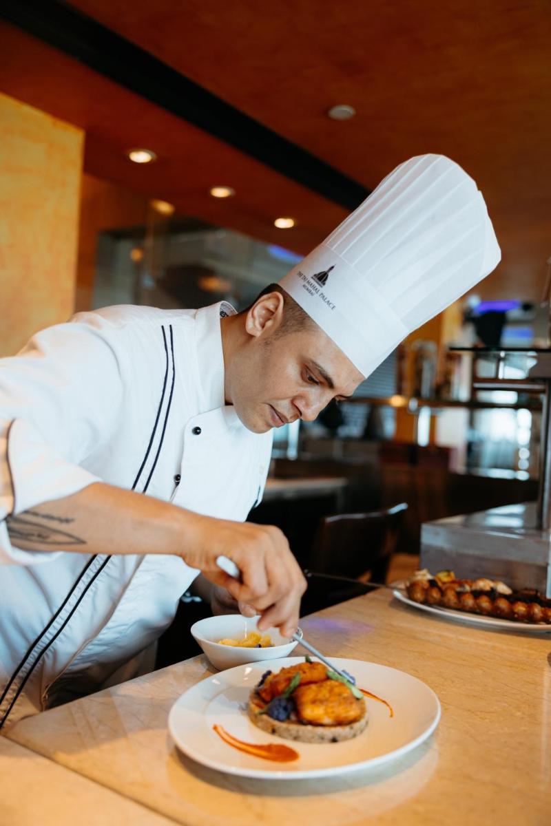 a chef preparing a plate of food on a table at The Taj Mahal Tower, Mumbai in Mumbai a chef preparing a plate of food on a table at The Taj Mahal Tower, Mumbai in Mumbai