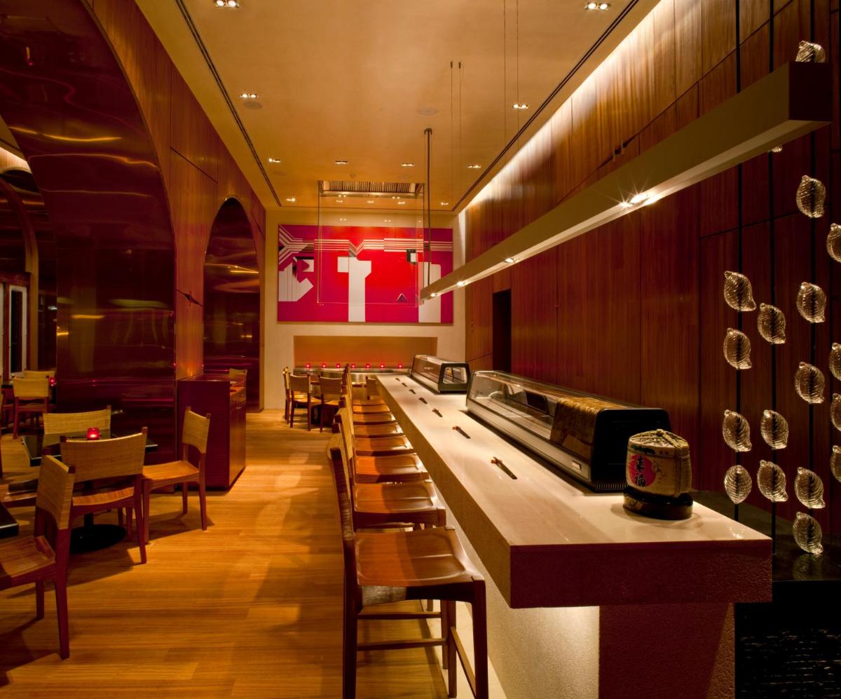 a restaurant with a long counter and some chairs at The Taj Mahal Tower, Mumbai in Mumbai a restaurant with a long counter and some chairs at The Taj Mahal Tower, Mumbai in Mumbai