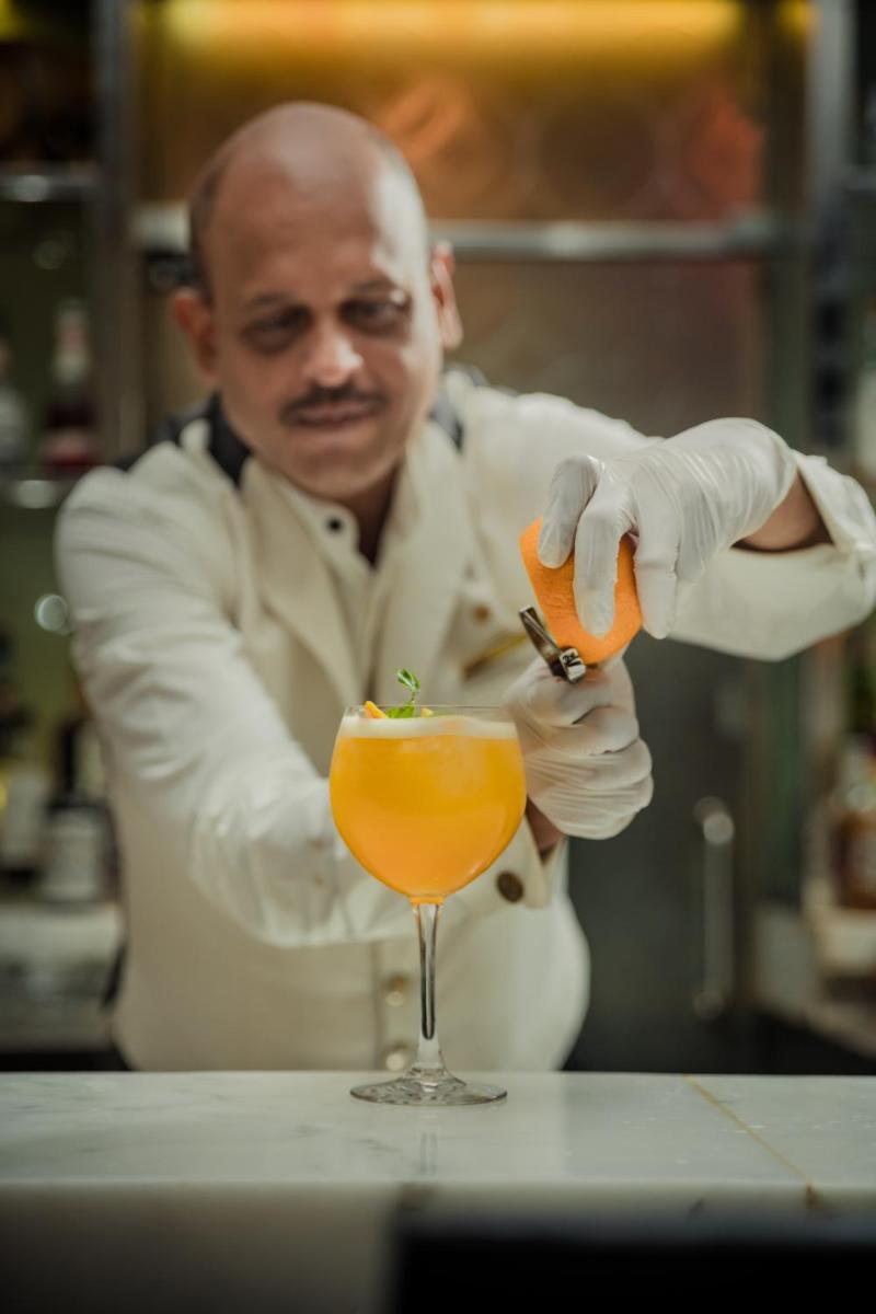 a man in a lab coat preparing a drink at The Taj Mahal Tower, Mumbai in Mumbai a man in a lab coat preparing a drink at The Taj Mahal Tower, Mumbai in Mumbai