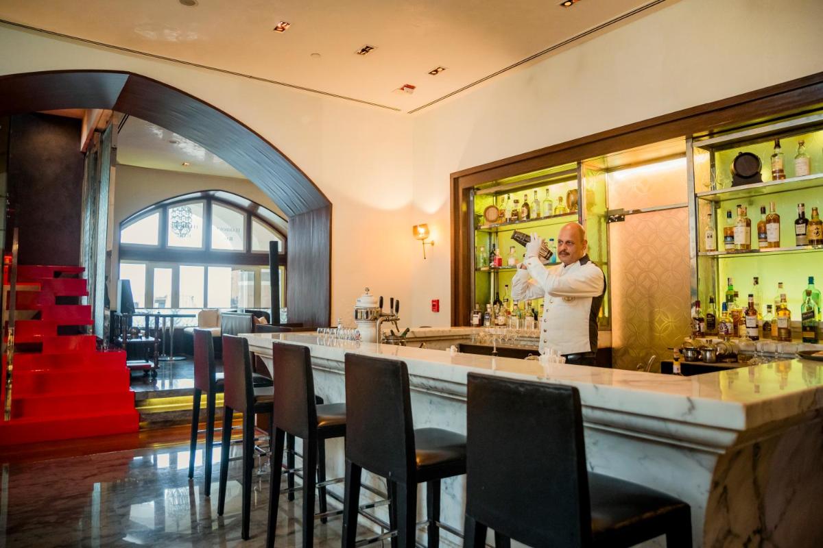 a man standing behind a bar in a restaurant at The Taj Mahal Tower, Mumbai in Mumbai a man standing behind a bar in a restaurant at The Taj Mahal Tower, Mumbai in Mumbai