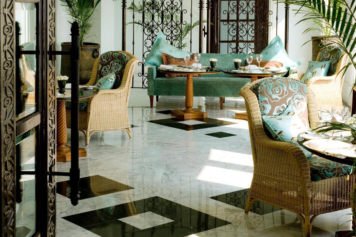 a living room with chairs and a table with food at The Taj Mahal Tower, Mumbai in Mumbai a living room with chairs and a table with food at The Taj Mahal Tower, Mumbai in Mumbai