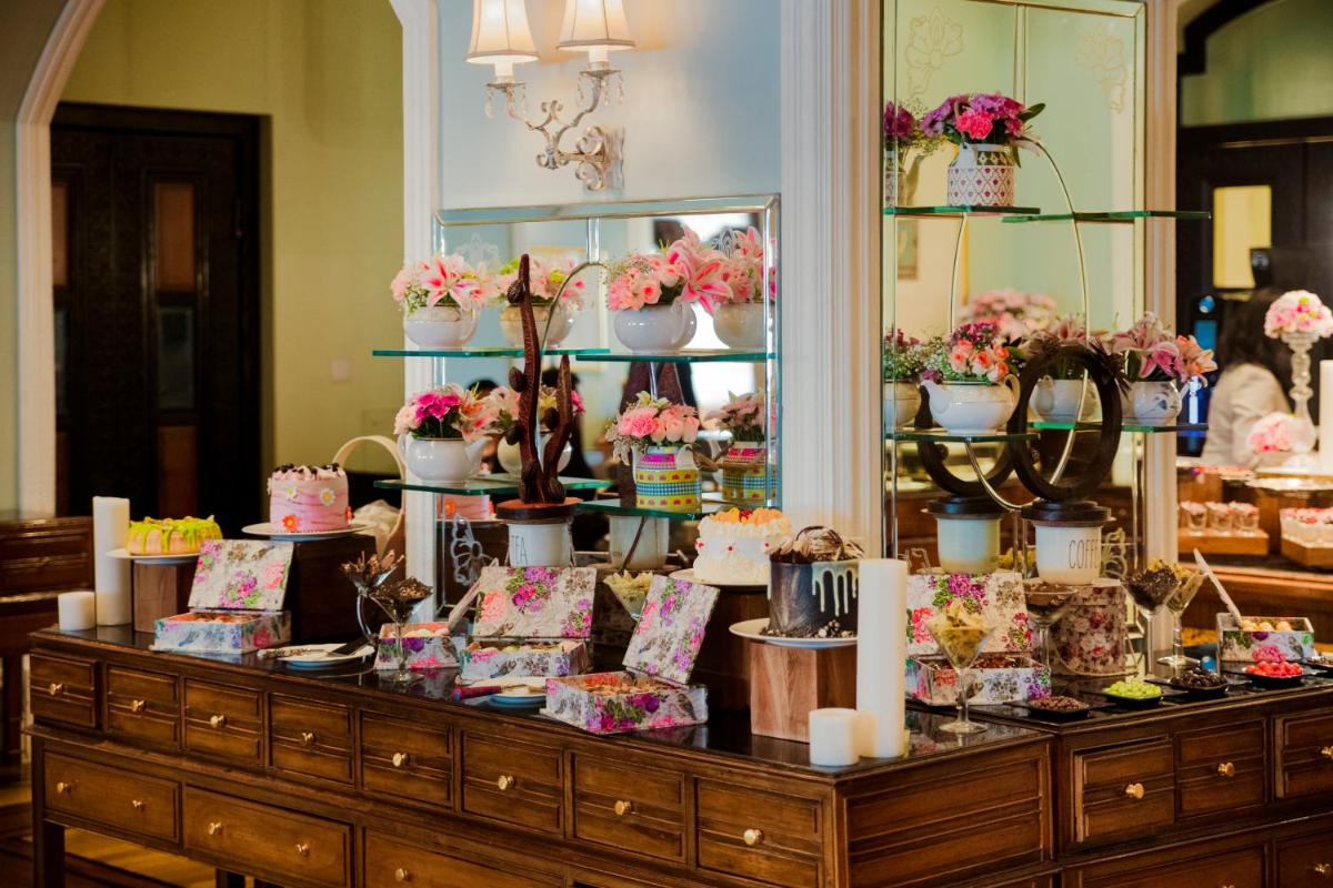 a display case with flowers and cakes on it at The Taj Mahal Tower, Mumbai in Mumbai a display case with flowers and cakes on it at The Taj Mahal Tower, Mumbai in Mumbai