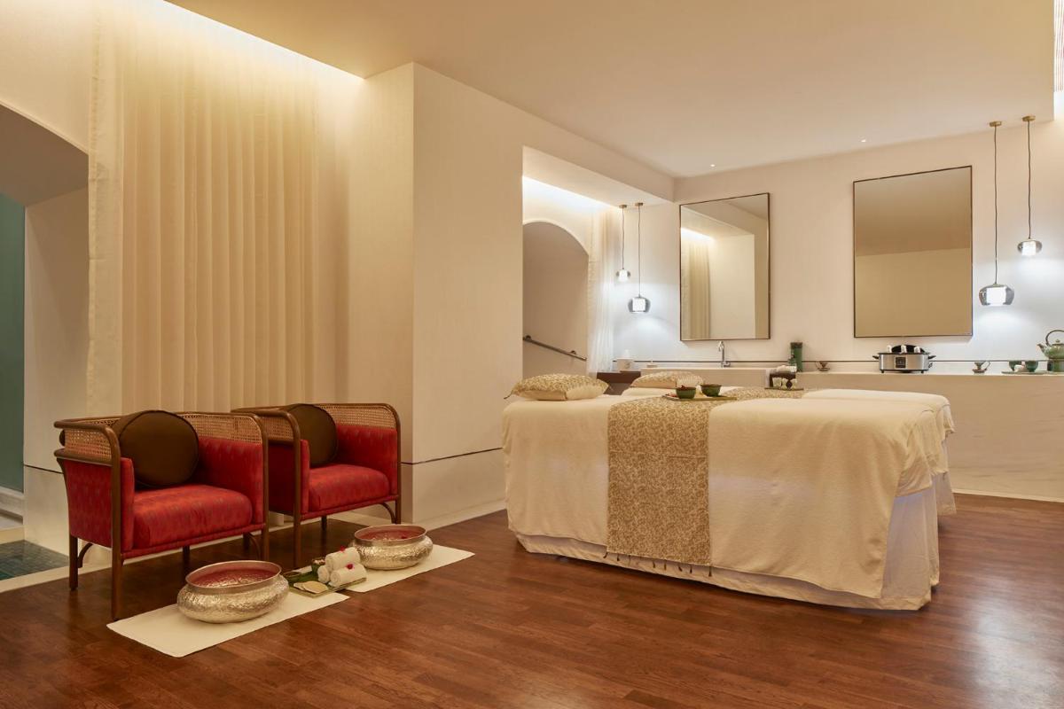 a bedroom with a large bed and two chairs at The Taj Mahal Tower, Mumbai in Mumbai a bedroom with a large bed and two chairs at The Taj Mahal Tower, Mumbai in Mumbai