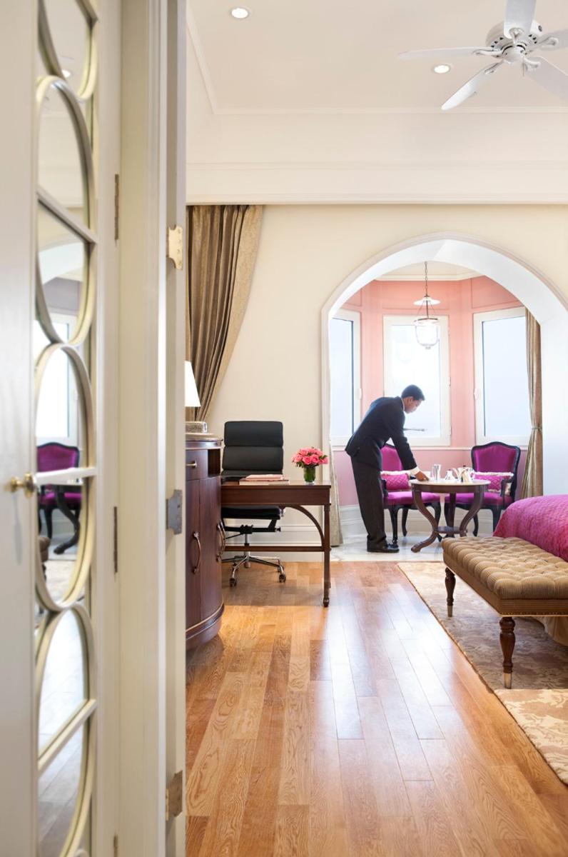 a woman standing in a living room with a table at The Taj Mahal Tower, Mumbai in Mumbai a woman standing in a living room with a table at The Taj Mahal Tower, Mumbai in Mumbai