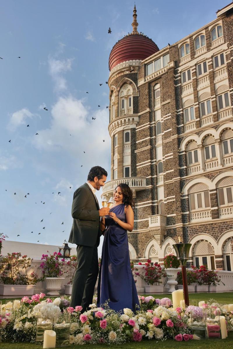 a man and woman standing in front of a building at The Taj Mahal Tower, Mumbai in Mumbai a man and woman standing in front of a building at The Taj Mahal Tower, Mumbai in Mumbai