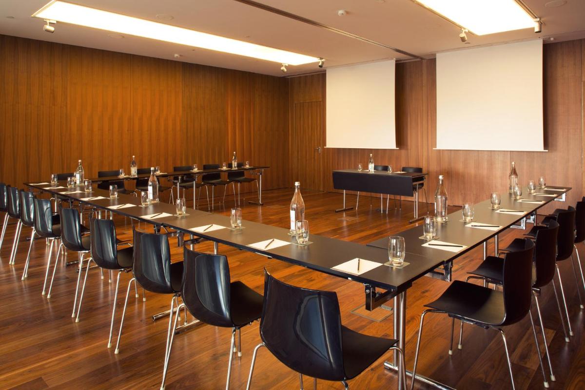 uma grande sala de conferências com uma mesa longa e cadeiras em Troia Design Hotel em Tróia mais 101 fotografias
