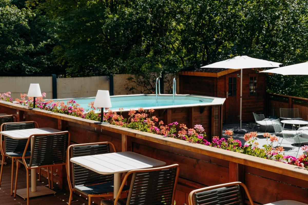 - une piscine avec des tables, des chaises et des fleurs dans l'établissement Hôtel Lyret, à Chamonix-Mont-Blanc