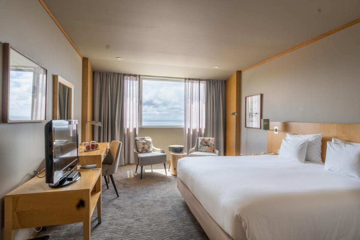 um quarto de hotel com uma cama e uma televisão em The Lince Azores em Ponta Delgada
