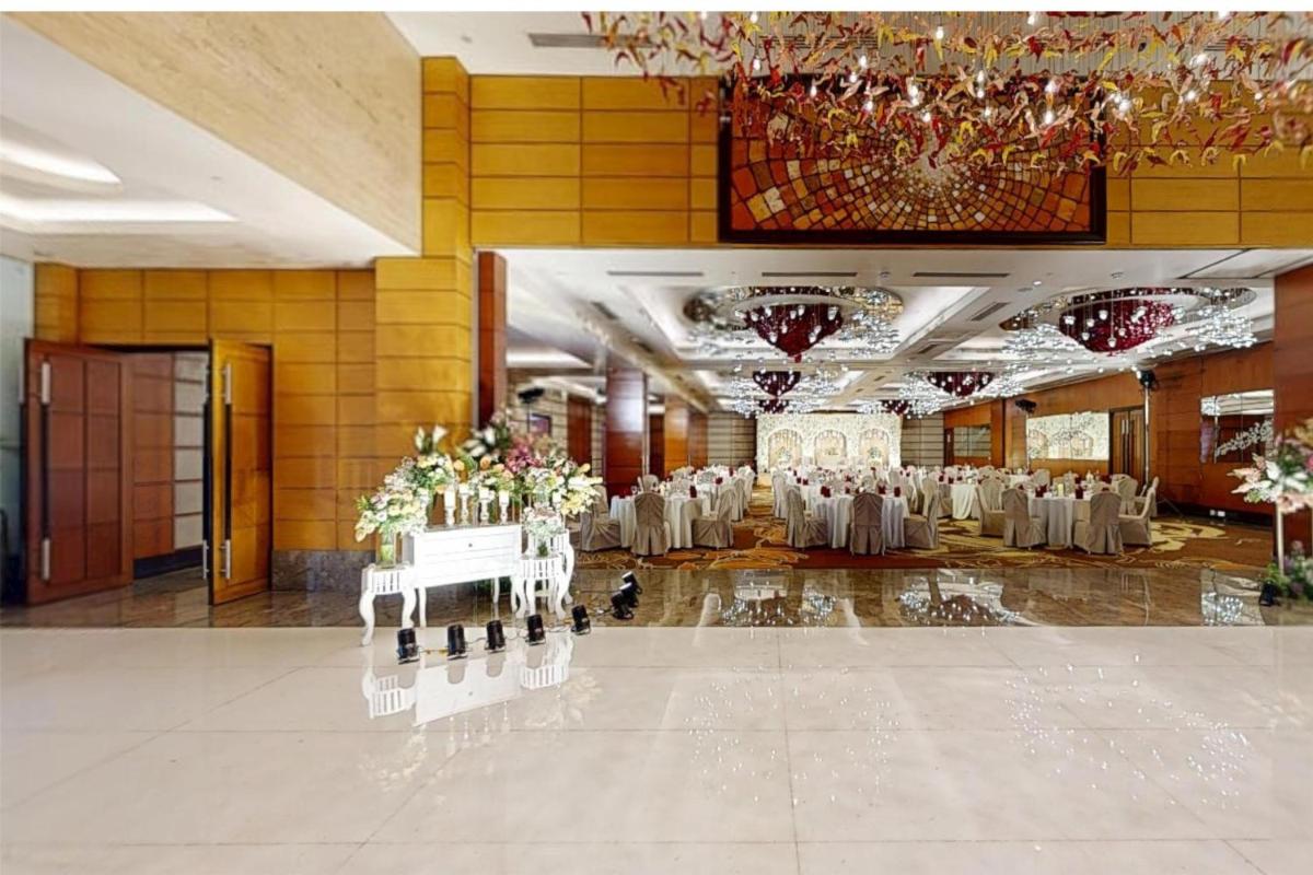 a large banquet hall with white tables and chairs at Radisson Blu Hotel, Nagpur in Nagpur