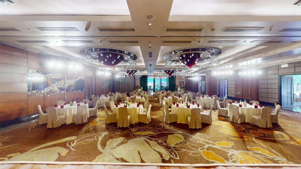a banquet hall with tables and chairs and chandeliers at Radisson Blu Hotel, Nagpur in Nagpur
