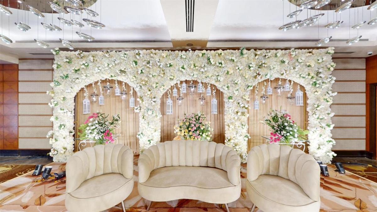 a wedding banquet hall with two chairs and flowers at Radisson Blu Hotel, Nagpur in Nagpur