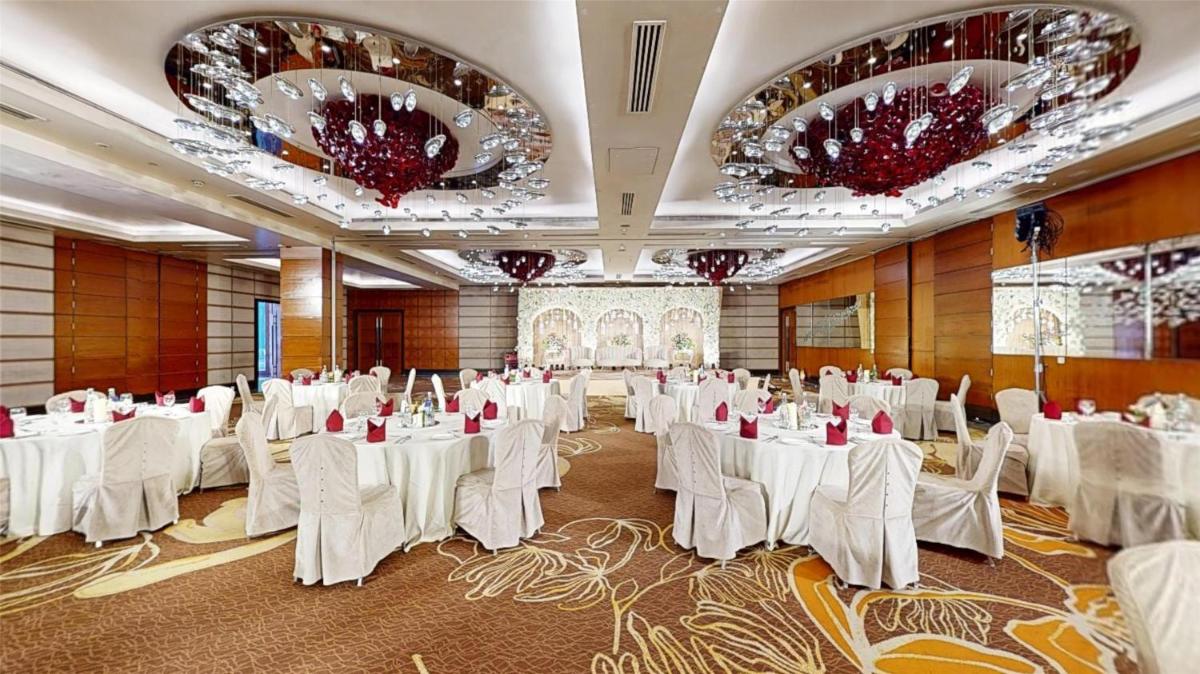 a banquet hall with white tables and chairs and chandeliers at Radisson Blu Hotel, Nagpur in Nagpur