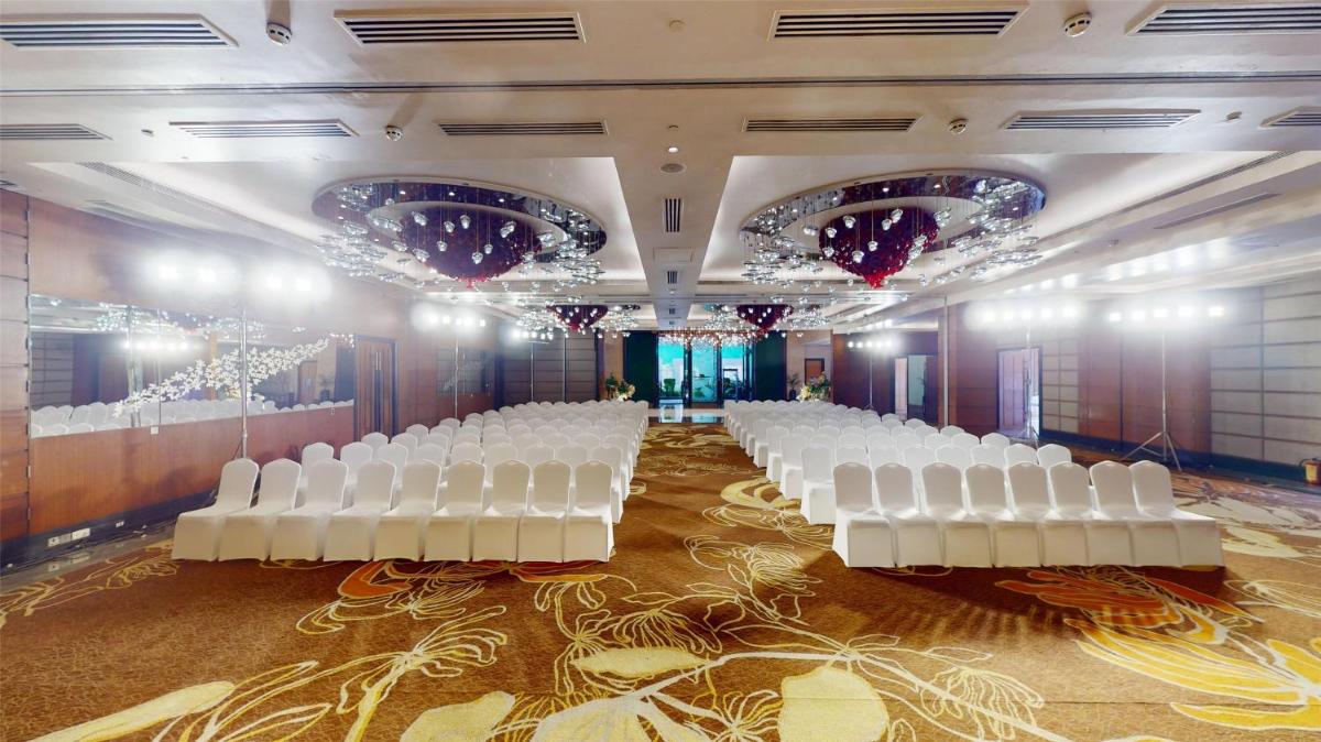 a row of white chairs in a banquet hall at Radisson Blu Hotel, Nagpur in Nagpur