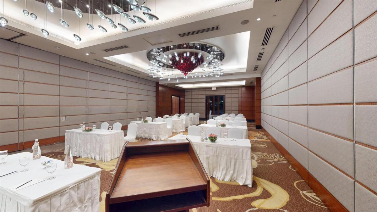 a banquet hall with white tables and chairs at Radisson Blu Hotel, Nagpur in Nagpur