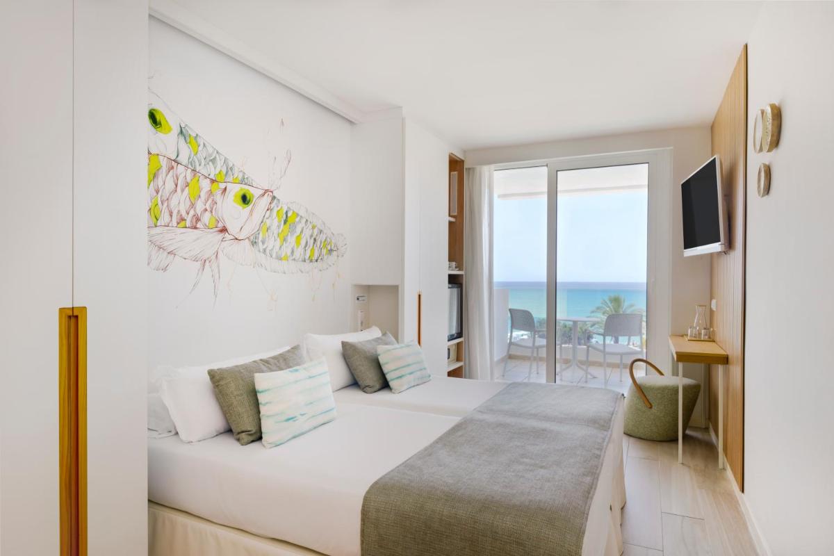 Un dormitorio con una cama con vista al mar. en Iberostar Waves Bahía de Palma - Adults Only, en Playa de Palma