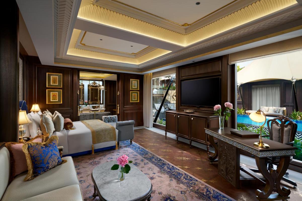 a hotel room with a bed and a television at The Leela Palace Udaipur in Udaipur