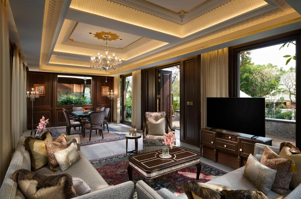 a living room with a couch and a television at The Leela Palace Udaipur in Udaipur