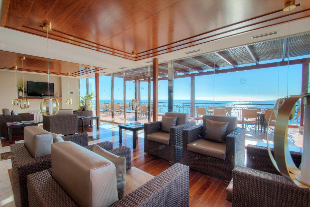 una sala de estar con sillas y mesas y vistas al océano. en Hotel Servigroup Montíboli, en Villajoyosa